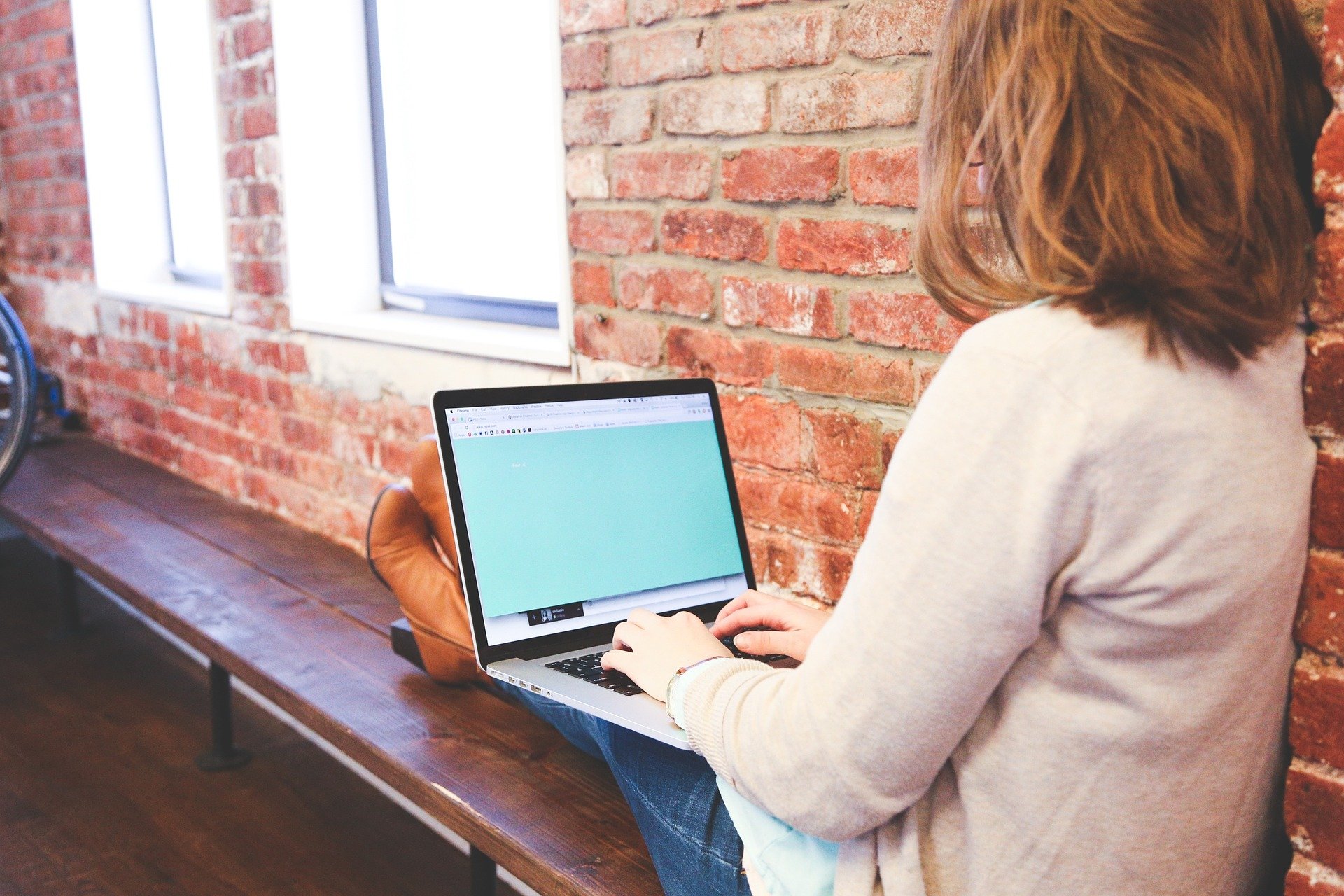 Student with a laptop sitting on a bench